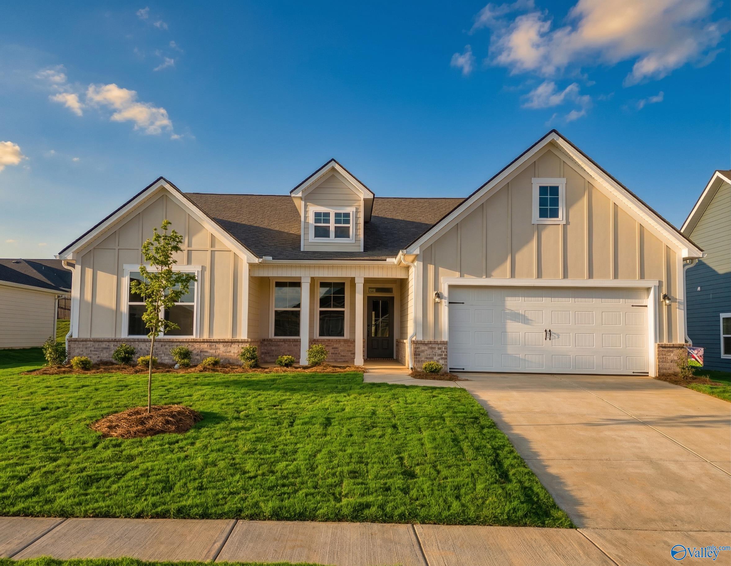 Beige one-story Davidson Homes The Rockford C with 2-car garage, front porch, and landscaped yard in Evergreen Mill, Madison, Alabama