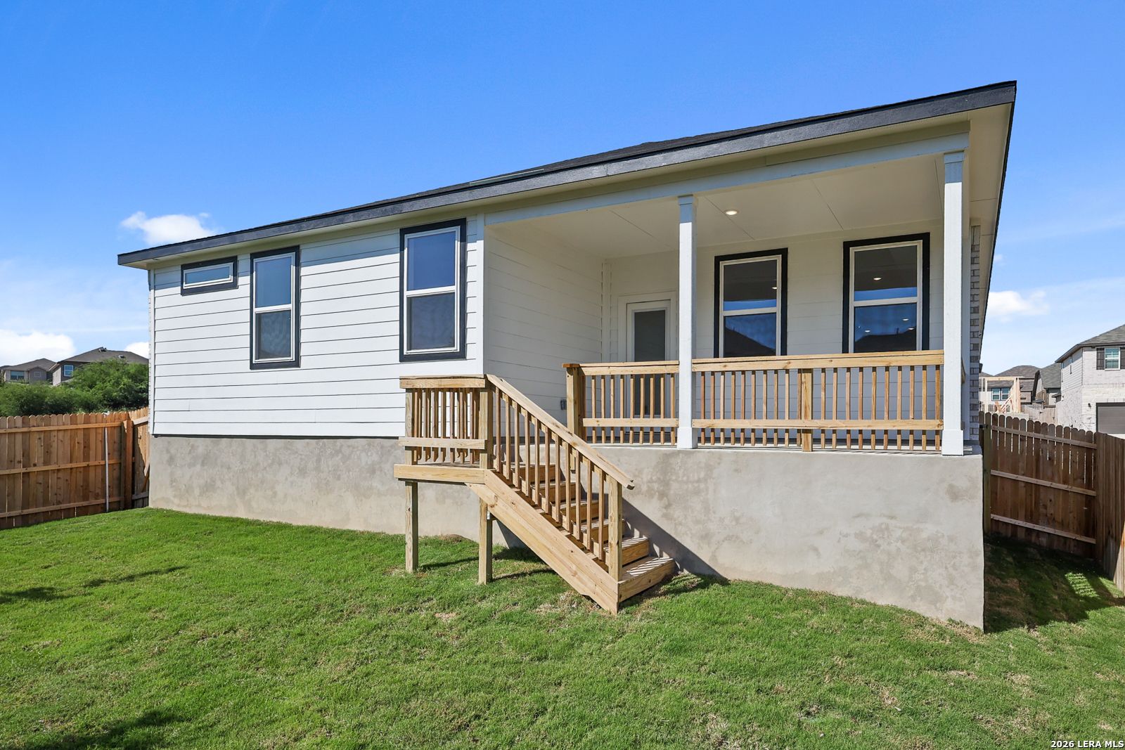 Covered back porch with wooden stairs and fenced backyard at Davidson Homes The Glenwood E in Comanche Ridge, San Antonio, Texas
