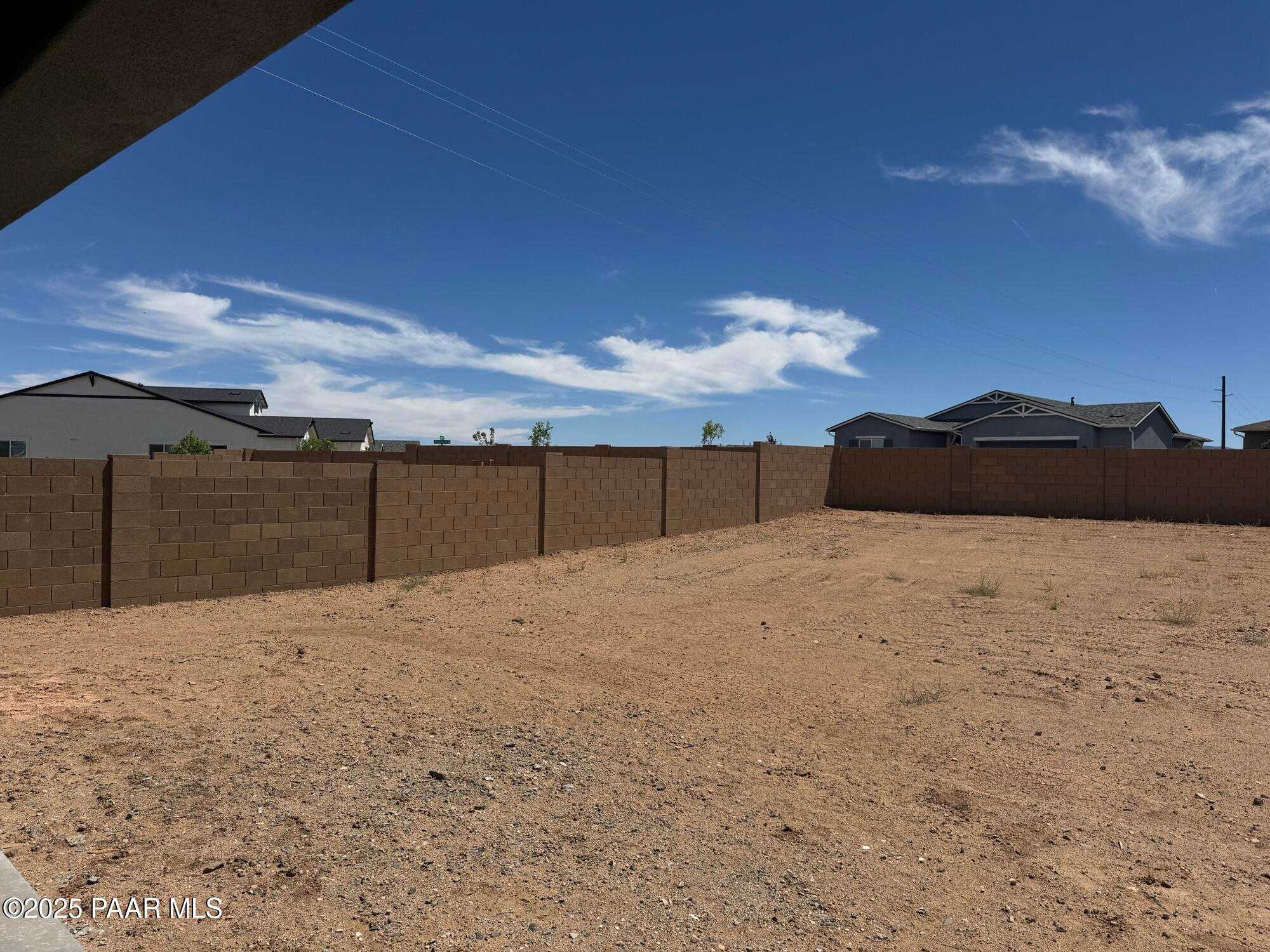 Enclosed dirt backyard with tan block walls and covered patio in Westwood neighborhood, Prescott Arizona Davidson Homes Sheridan II B