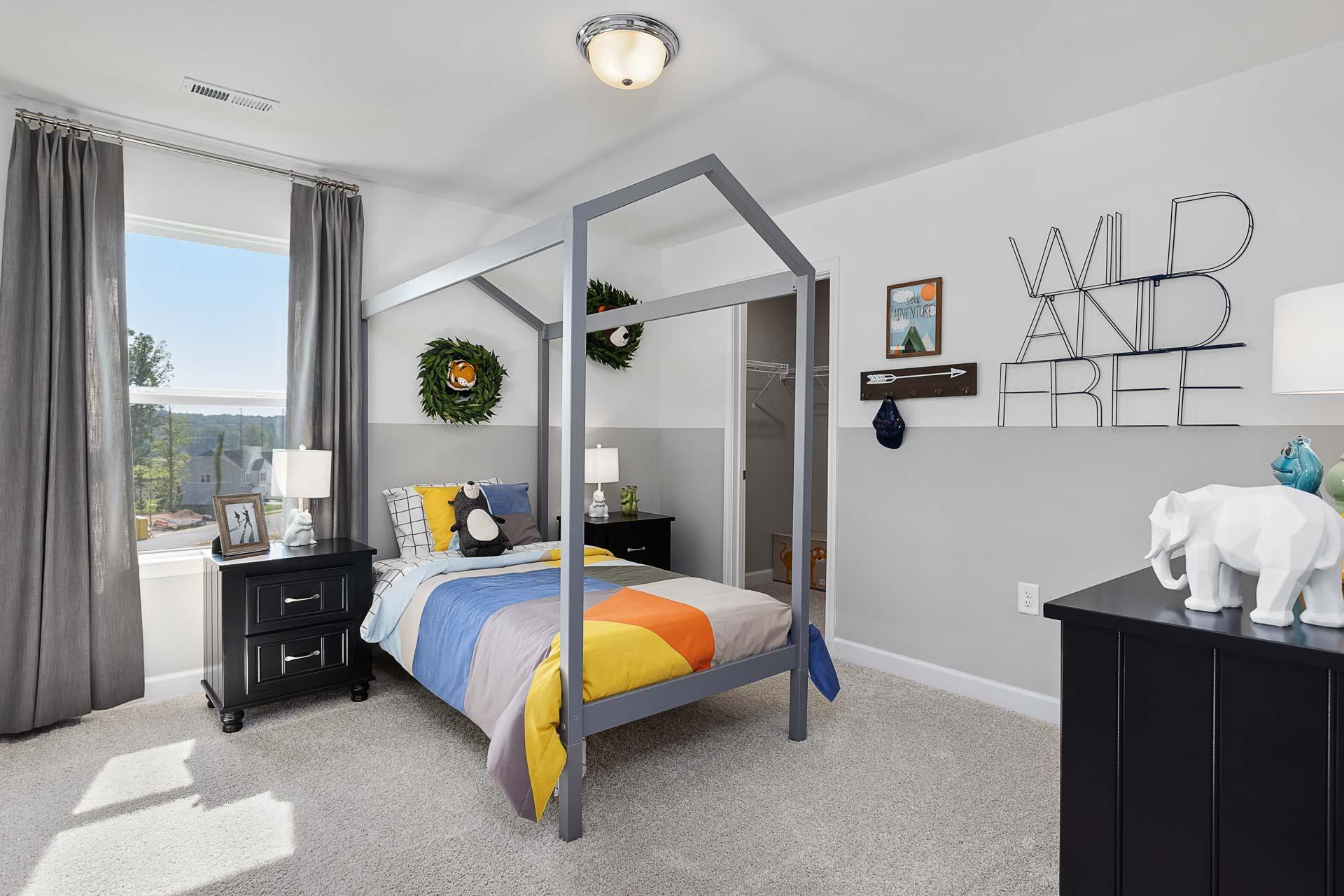 Cozy kids bedroom in Highland Forest Fuquay-Varina NC with house-frame bed colorful bedding wild and free wall decor