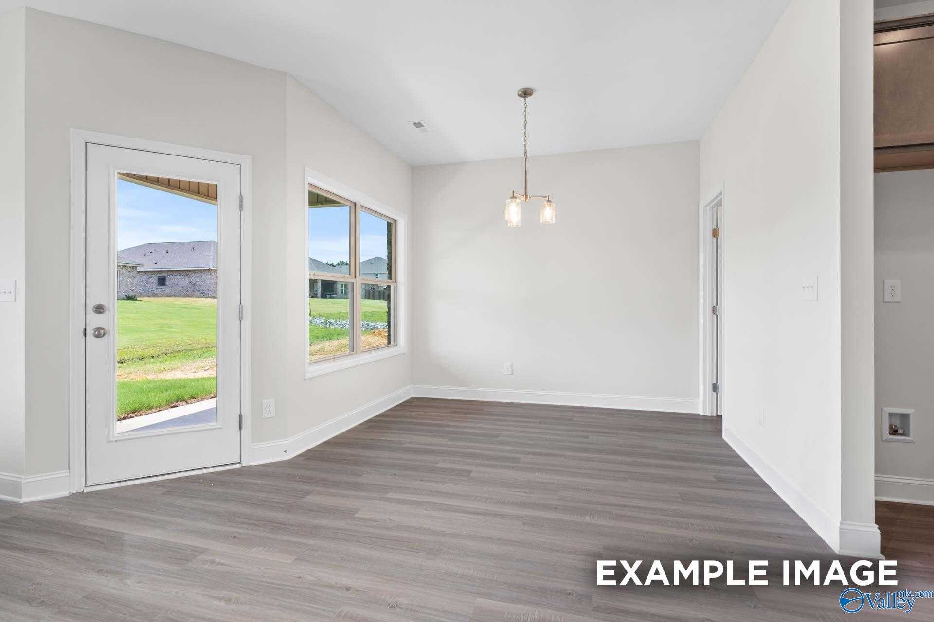 Bright entryway with large windows and door overlooking green yard in The Daphne D 4-bedroom home, Arab, Alabama