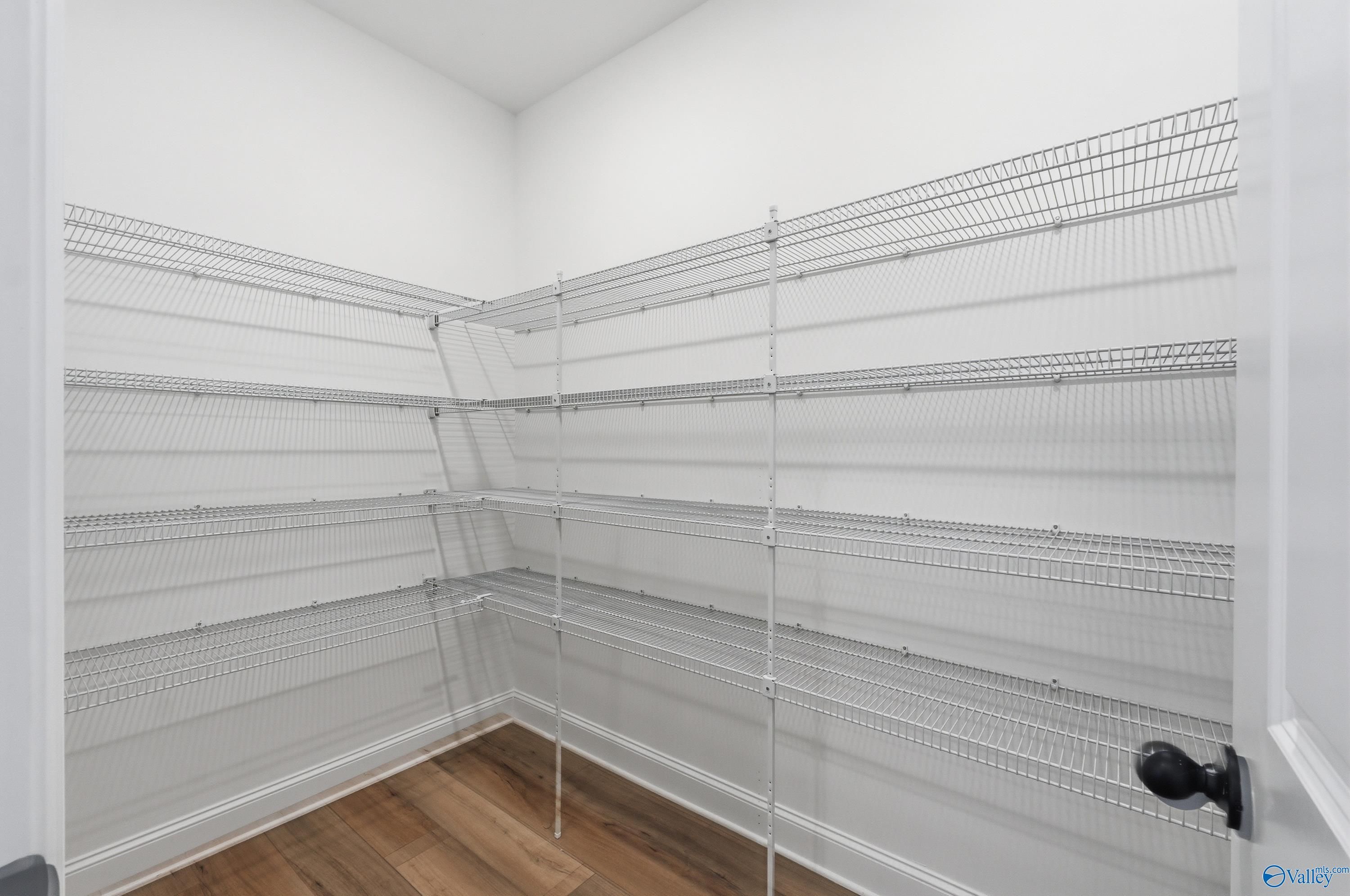Spacious walk-in closet with wire shelving and hardwood floors in The Laurel K, Davidson Homes, Cullman, Alabama
