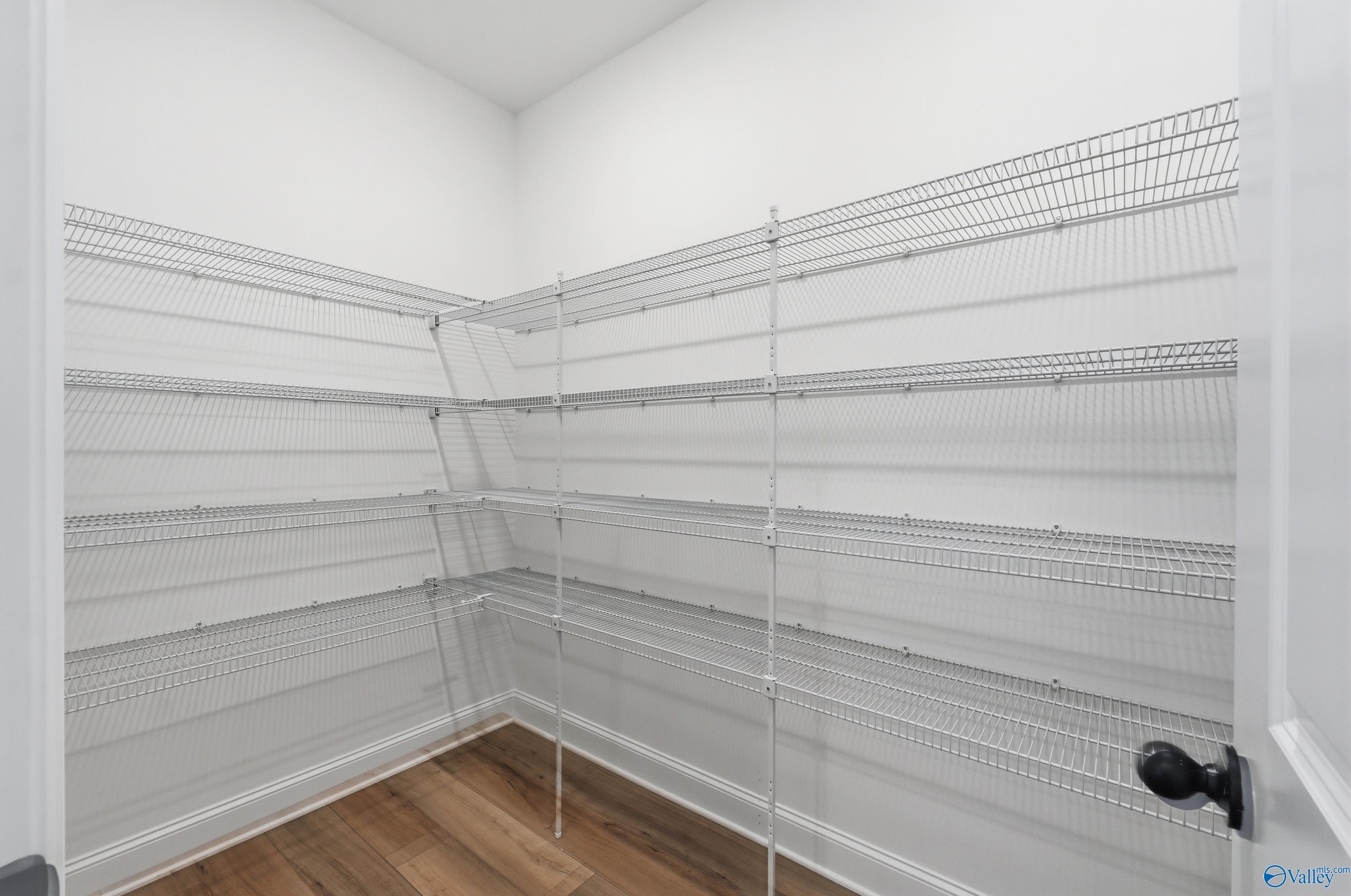 Spacious walk-in closet with wire shelving and hardwood floors in The Laurel K, Davidson Homes, Cullman, Alabama