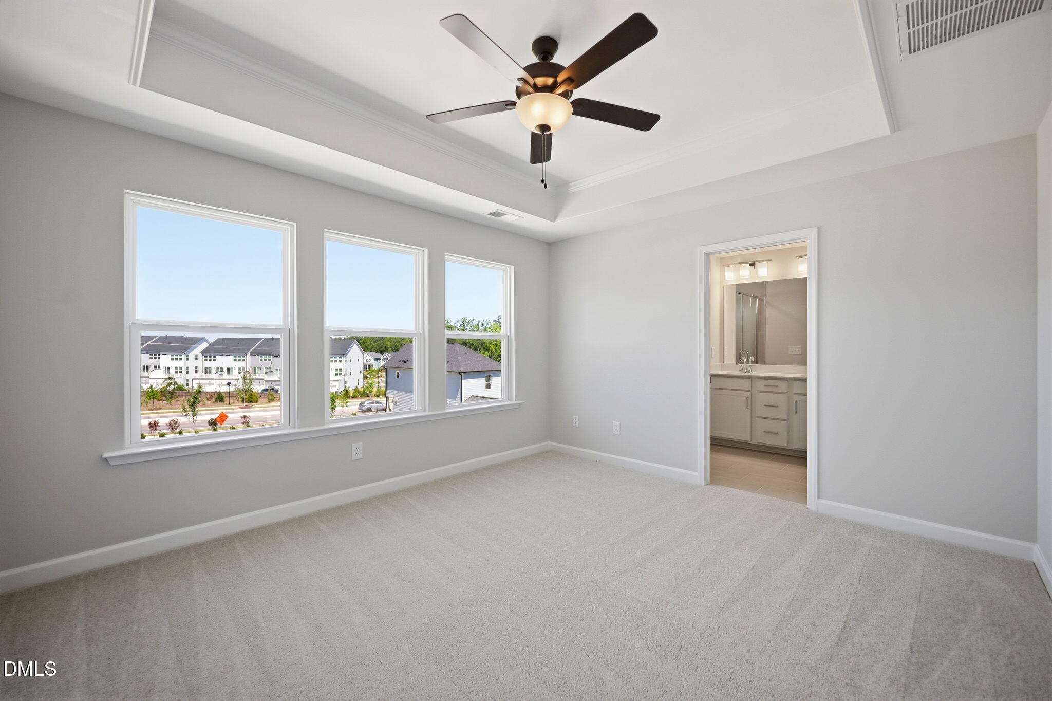 Bright bedroom with tray ceiling and en-suite bath in The Avery floor plan at Forestville Yard Townhomes, Knightdale, NC.