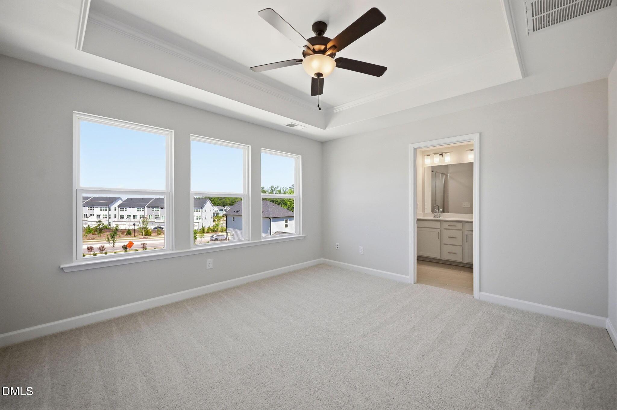 Bright bedroom with tray ceiling and en-suite bath in The Avery floor plan at Forestville Yard Townhomes, Knightdale, NC.