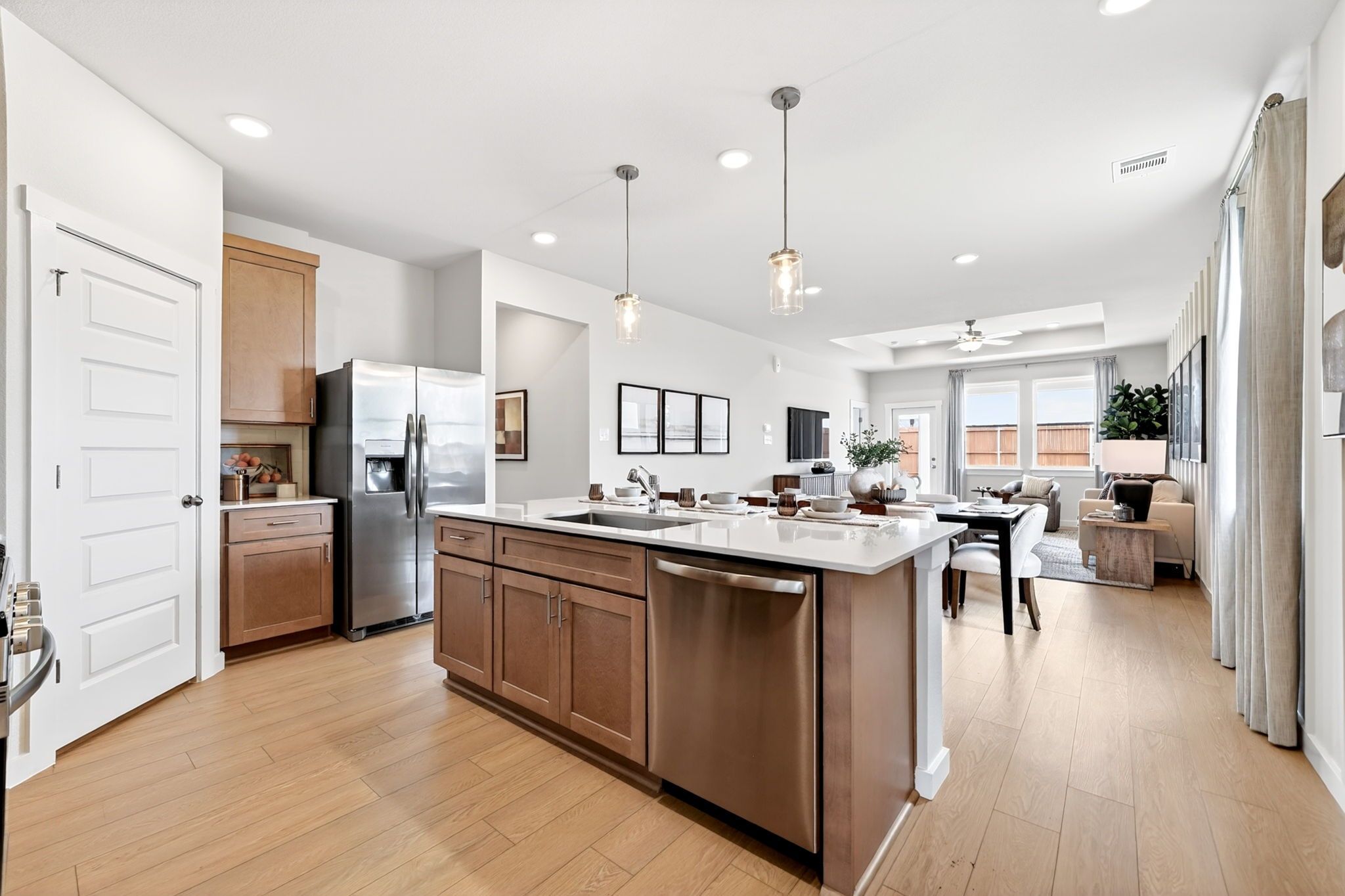 Spacious open-concept kitchen in Heartland Texas with large wood island, stainless steel appliances, and hardwood floors