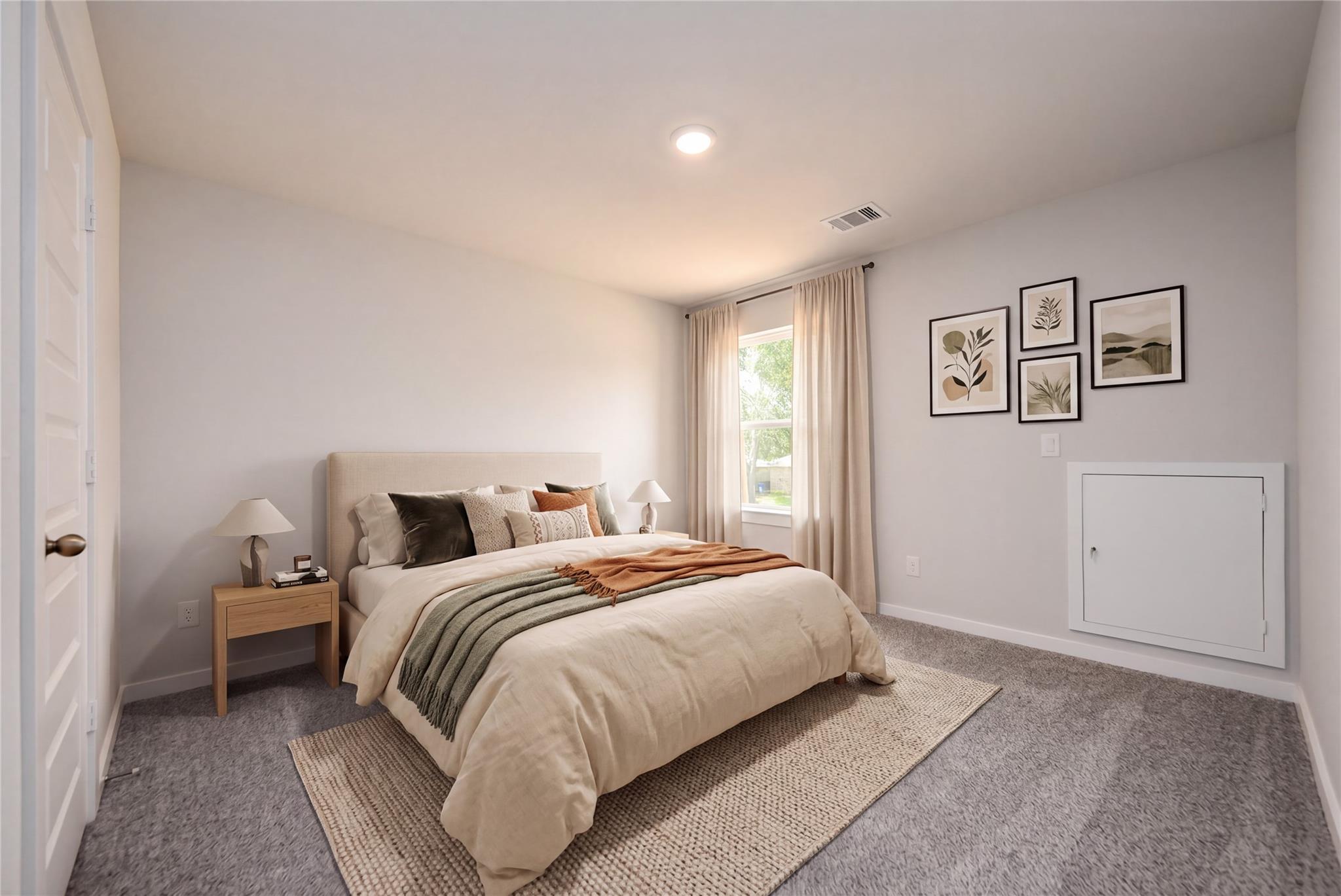 Cozy secondary bedroom with neutral decor in The Sabine E floor plan at Windmill Estates in Magnolia, Texas.