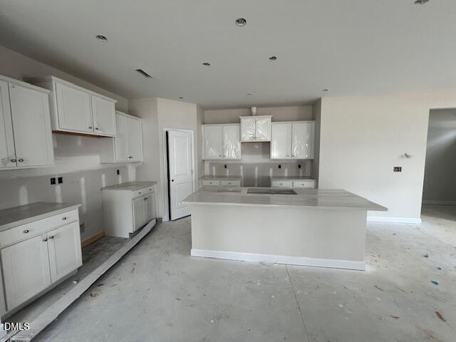 Modern white shaker kitchen with quartz island, stainless hood, and recessed lights in The Preston A 4-bedroom home, Lillington NC