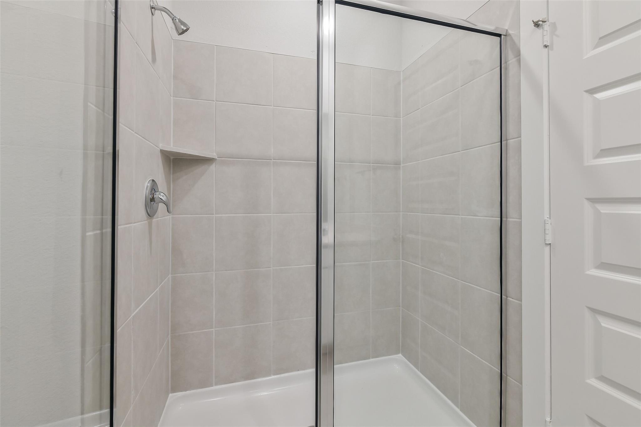 Modern glass shower with white subway tile walls and niche shelf in master bath, Davidson Homes The Colorado F, Cleveland, TX