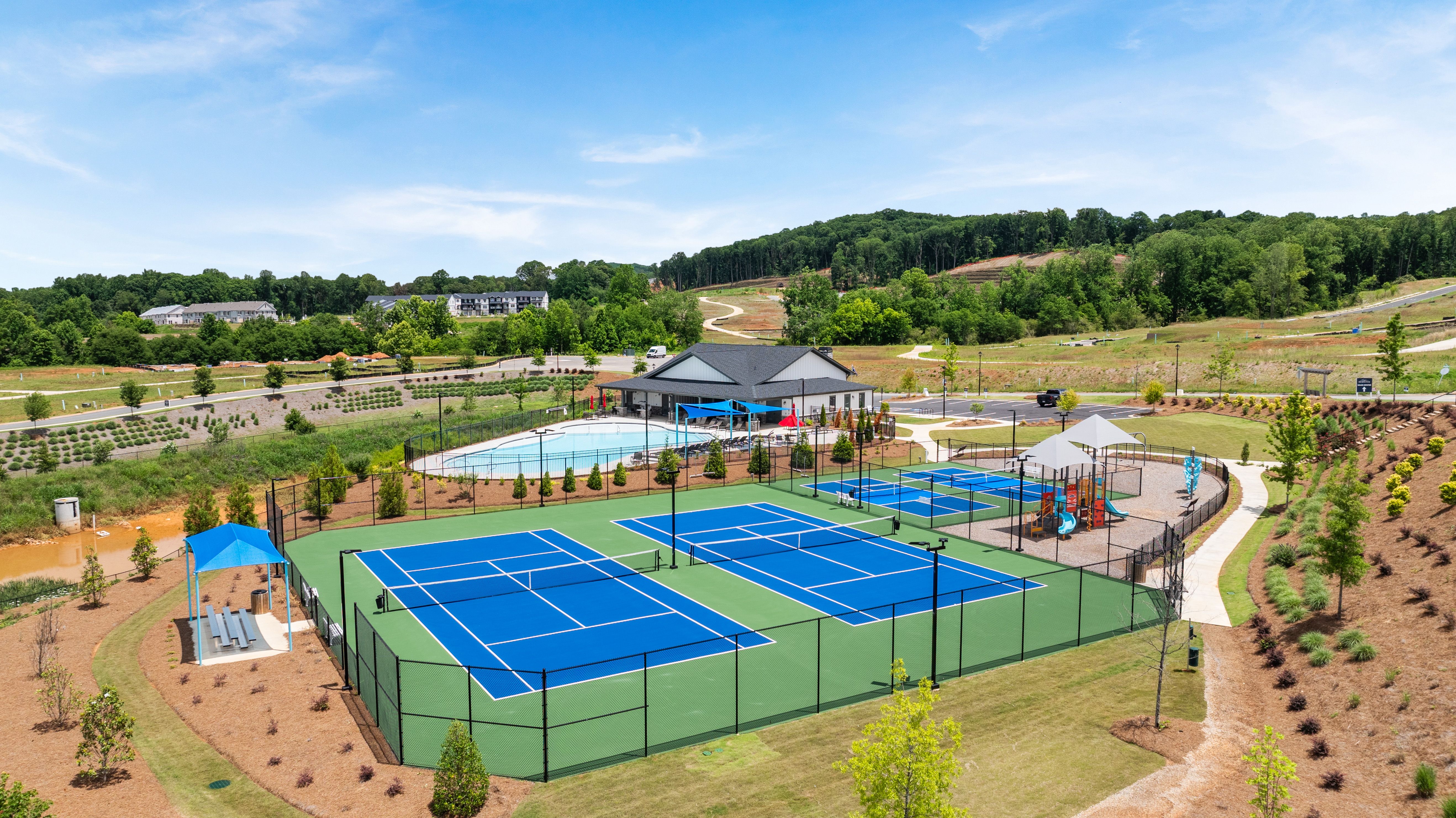 Tennis courts, swimming pool, and playground at Hemingway in Cumming, GA, a community built by Davidson Homes.