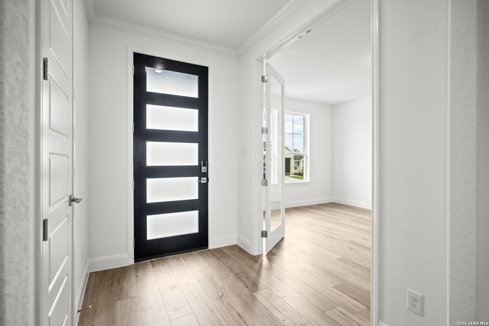 Modern entryway with black front door and French doors leading to a home office in The Lanier G floor plan, Castroville.