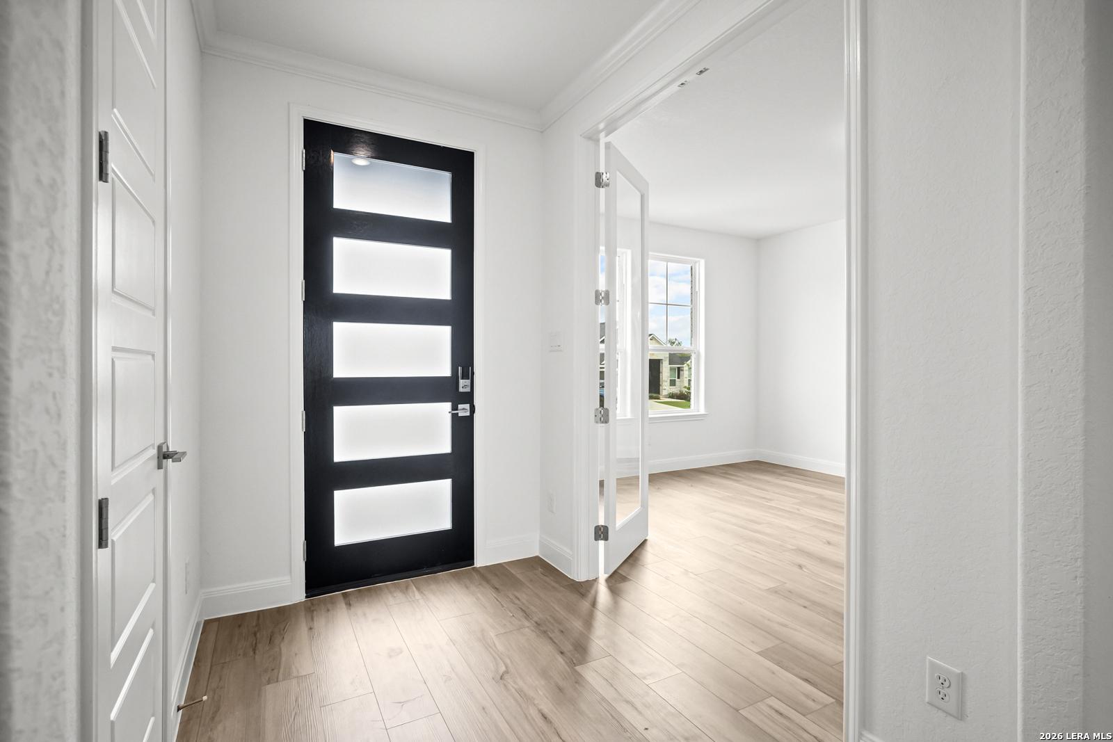 Modern entryway with black front door and French doors leading to a home office in The Lanier G floor plan, Castroville.