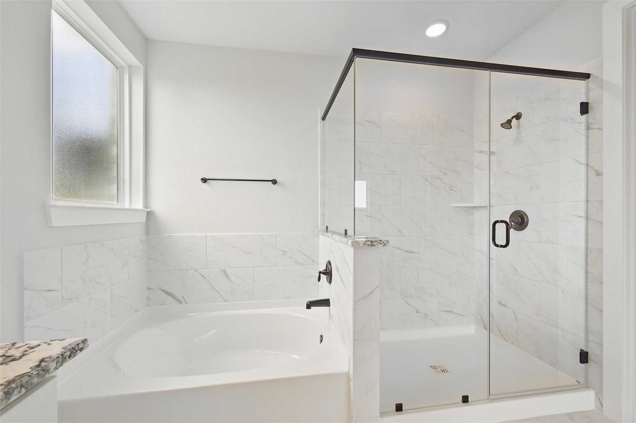 Modern master bathroom with frameless glass shower, soaking tub, and white subway tiles in Davidson Homes The Victoria C, Lago Mar