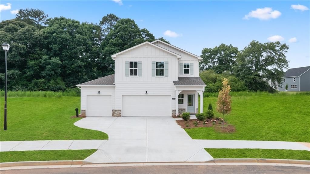 Two-story, white farmhouse-style Sinclair B floor plan by Davidson Homes with a 3-car garage in Cedar Farms, Winder, GA.