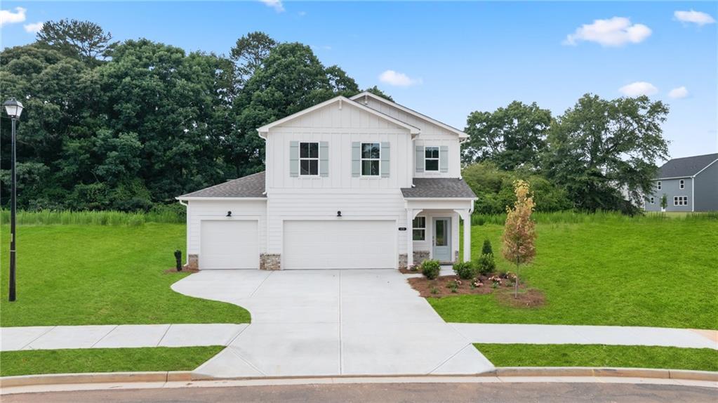 Two-story, white farmhouse-style Sinclair B floor plan by Davidson Homes with a 3-car garage in Cedar Farms, Winder, GA.