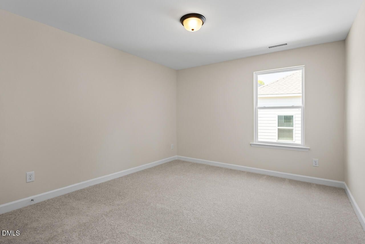 Bright neutral bedroom with carpet and ceiling light in Davidson Homes The Birch II C at Sage on North Main, Wake Forest, NC
