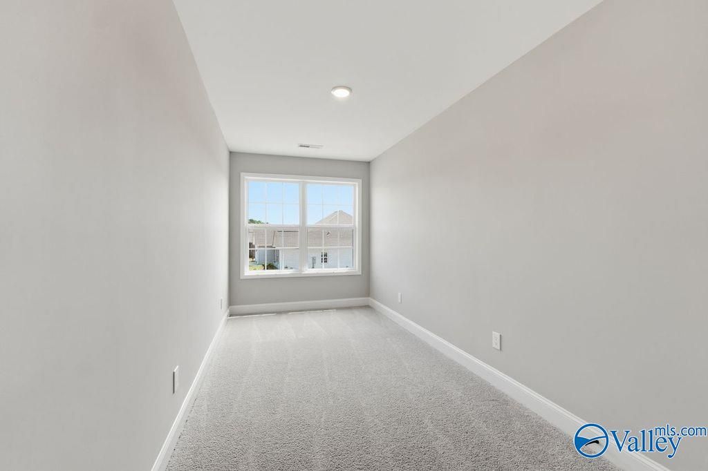 Bright, carpeted bonus room in The Rockford floor plan by Davidson Homes in Cain Park, Hartselle, Alabama.