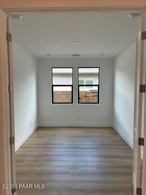 Bright empty bedroom with wood-look flooring and dual windows in Davidson Homes Durango II G, South Ranch, Prescott, Arizona