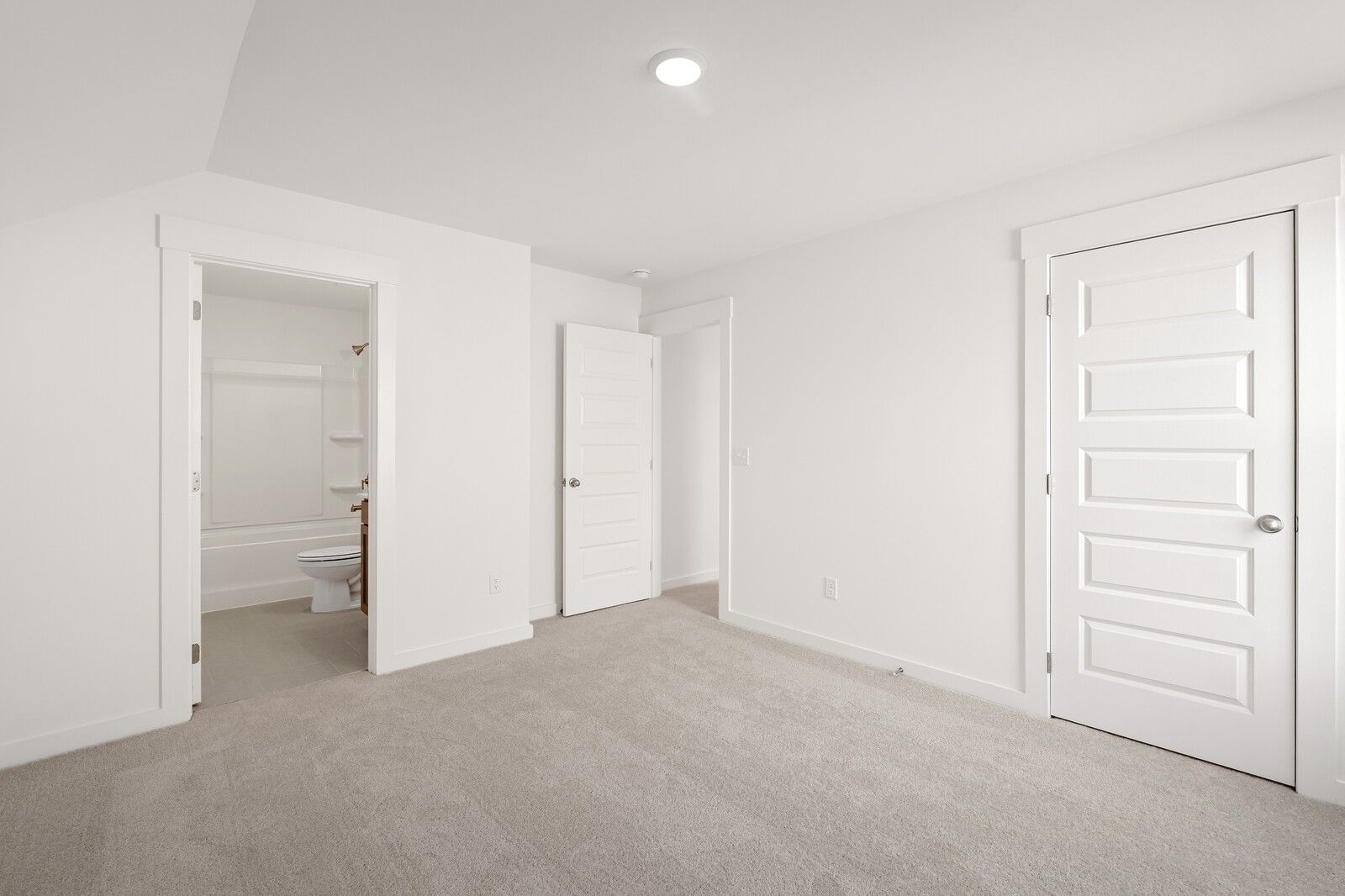 Spacious secondary bedroom with attached full bath, white walls, and carpet flooring in Davidson Homes The Ash C, Mt. Juliet