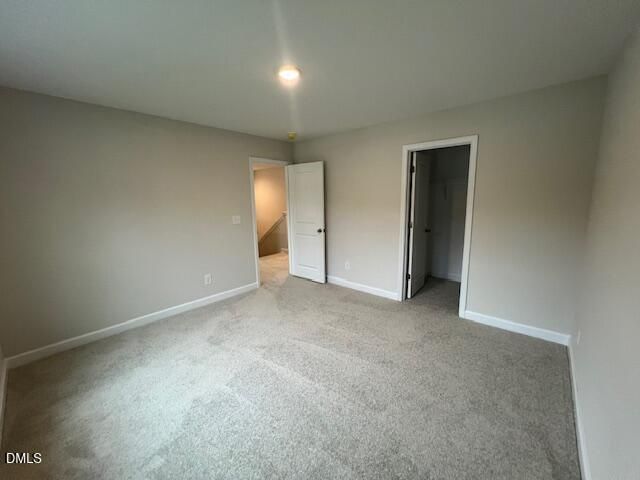 Spacious carpeted bedroom with neutral walls and walk-in closet in Davidson Homes The Willow D, Wellers Knoll, Lillington, NC