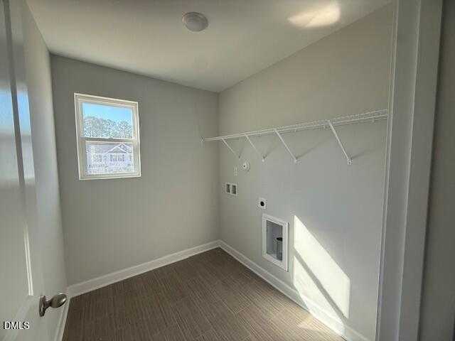 Spacious laundry room with gray walls, built-in shelving, and washer-dryer hookups in Davidson Homes The Gavin B, Lillington, NC
