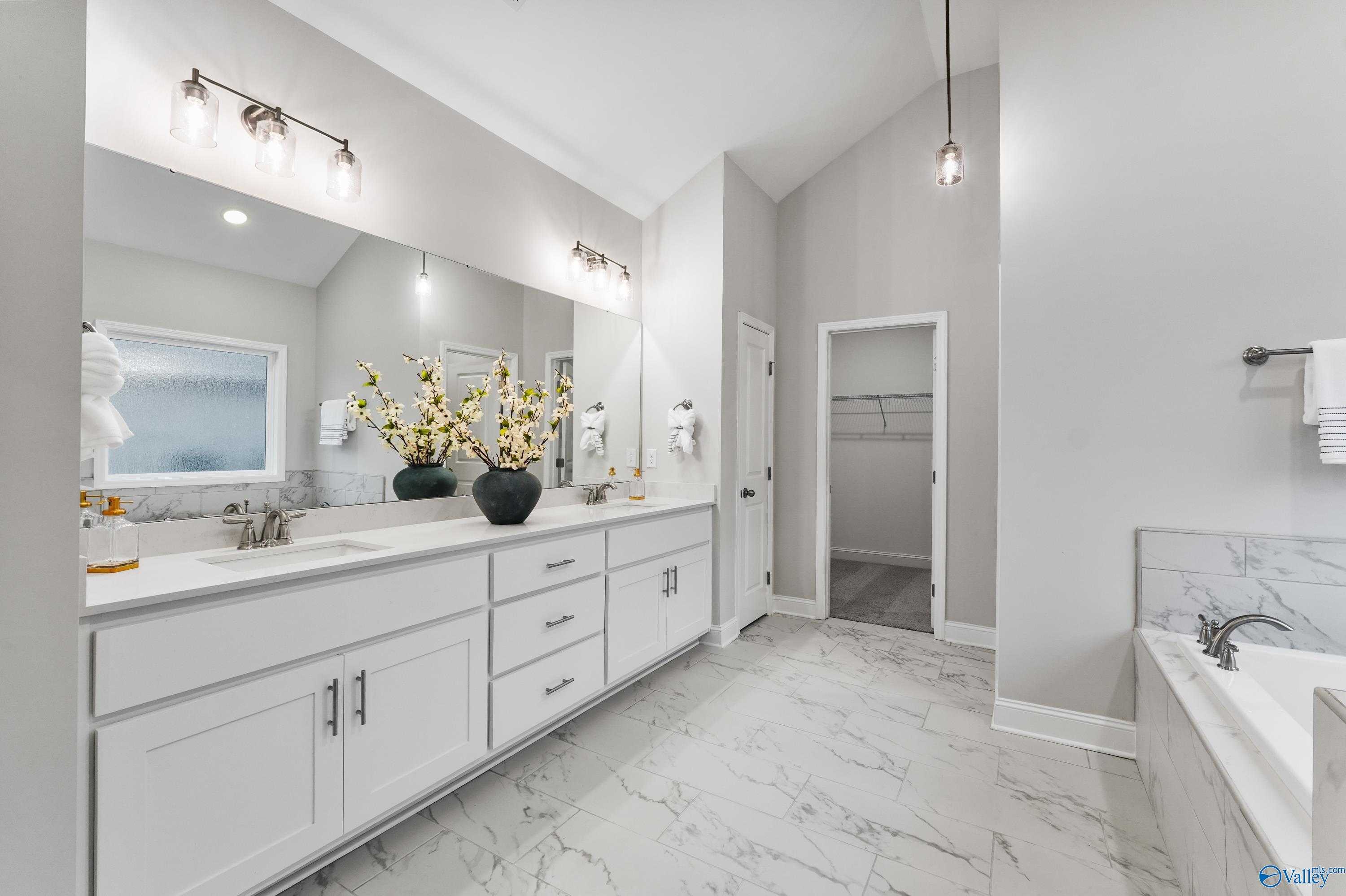 Luxurious master bathroom with double marble vanity, freestanding tub, and pendant lights in Davidson Homes The Finleigh, Toney, Alabama