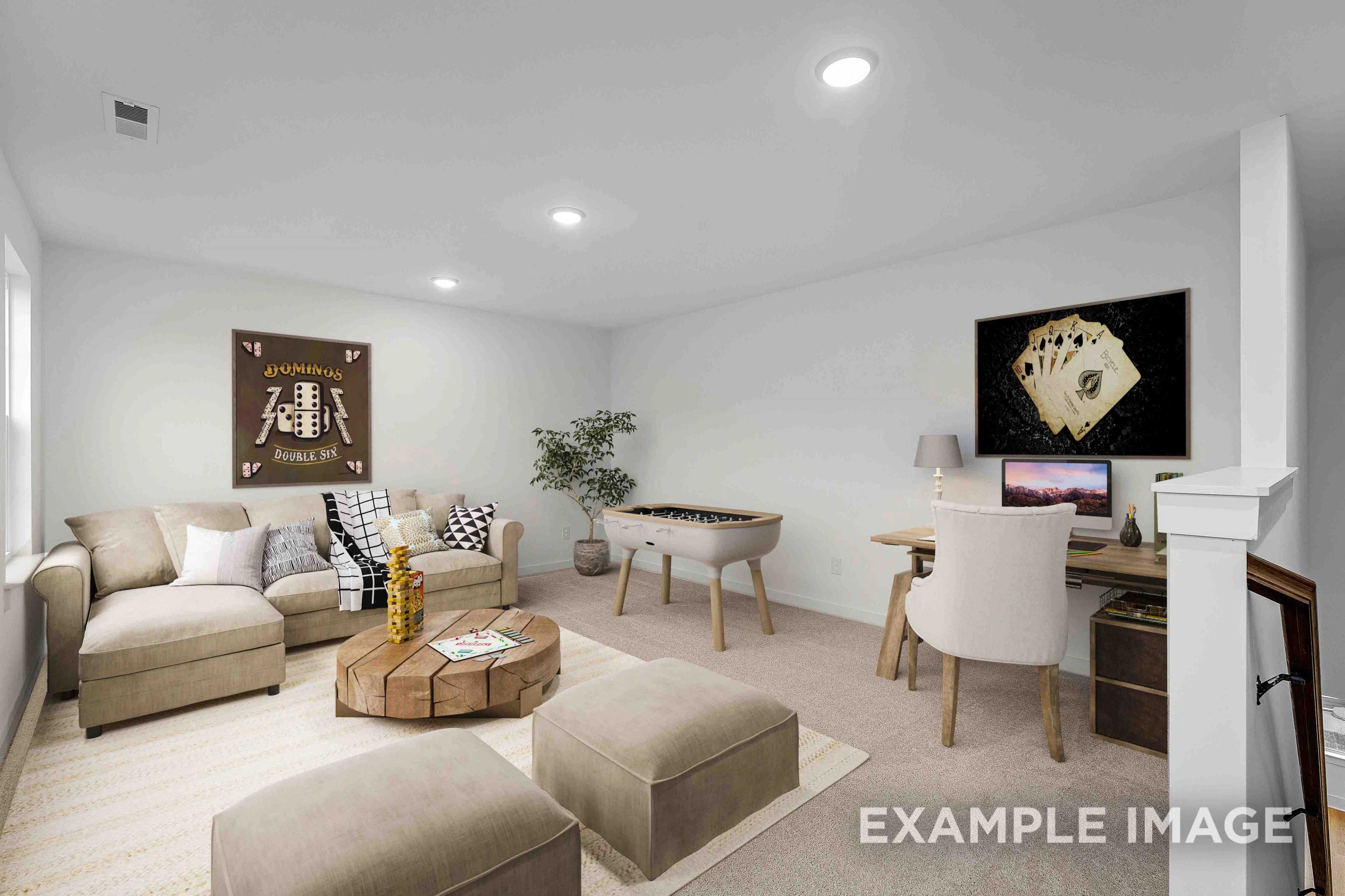 Spacious bonus room in The Charleston with beige sectional sofa, foosball table, wooden desk, and gaming wall art