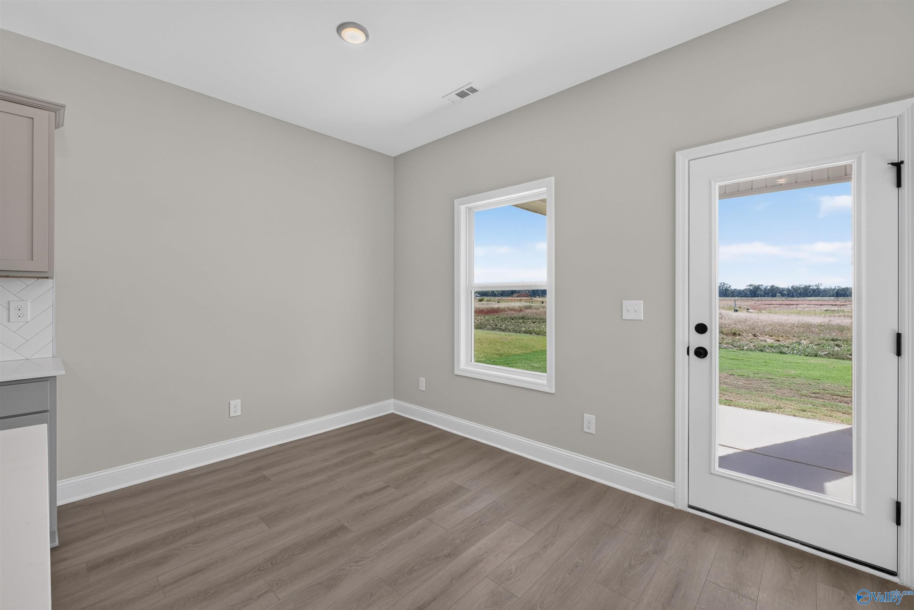 Bright dining area with glass-panel back door and backyard views in Davidson Homes The Butler floor plan, Hazel Green, Alabama