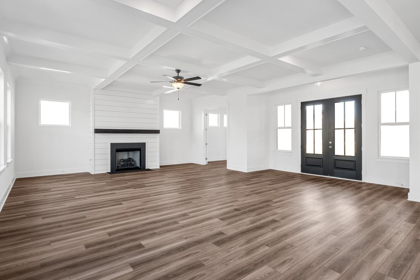 Spacious family room featuring shiplap fireplace, coffered ceiling fan, hardwood floors in The Alston A by Davidson Homes, Murfreesboro