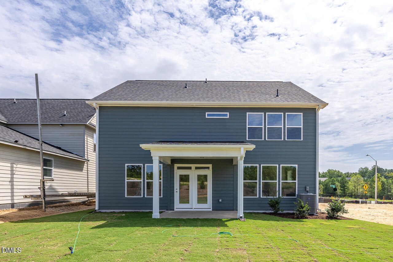 Blue-gray two-story exterior of The Chestnut floor plan by Davidson Homes with covered back patio in Wendell Ridge, NC.