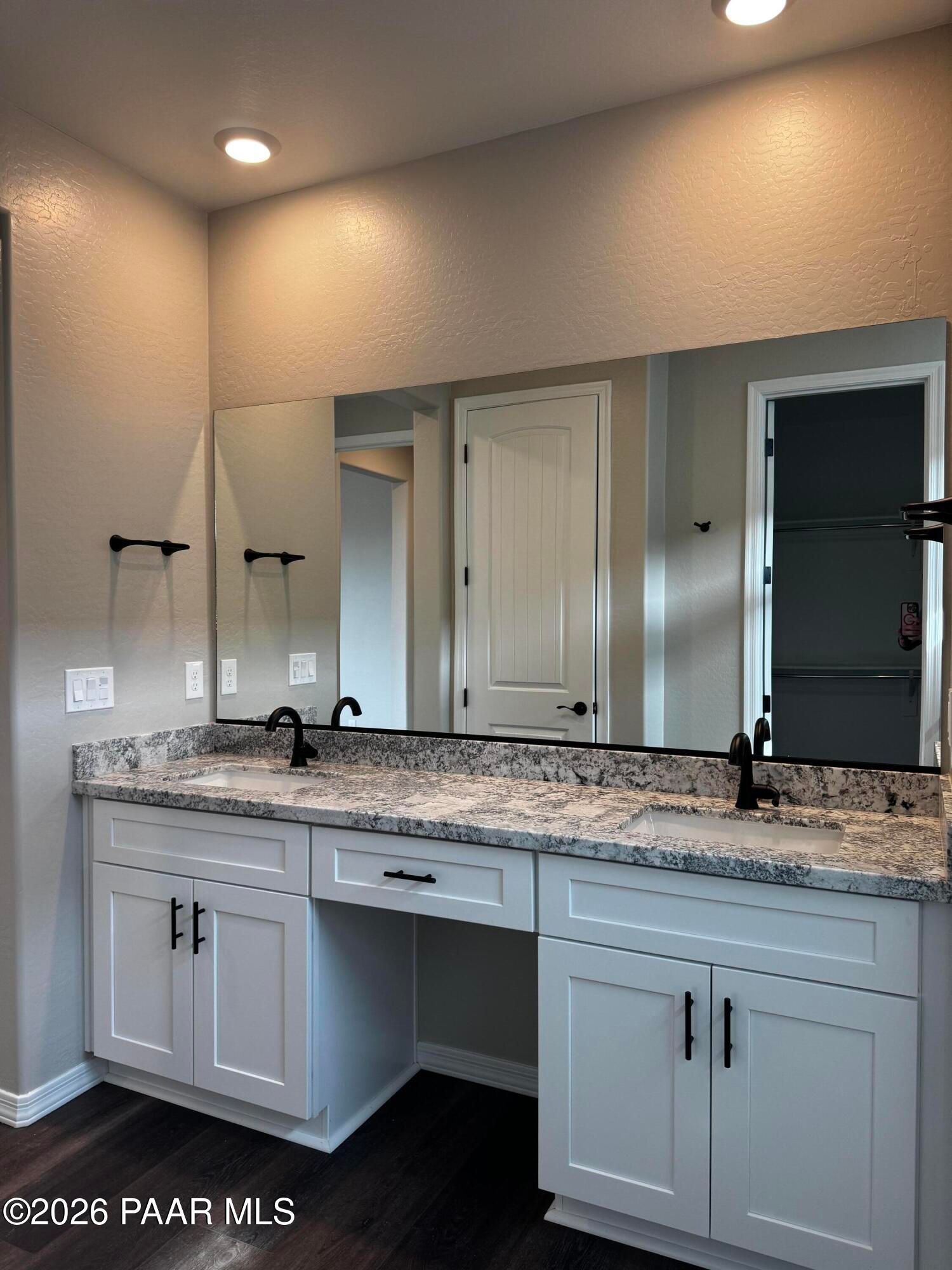 Modern double vanity with white cabinets, granite countertop, and black faucets in master bath of Davidson Homes Durango II B, Prescott AZ