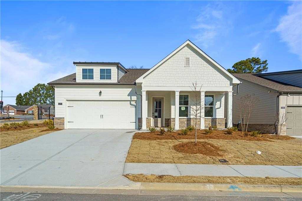 White single-story Davidson Homes The Edison A with 2-car garage, covered porch, and landscaped yard in Kelly Preserve, Loganville, GA