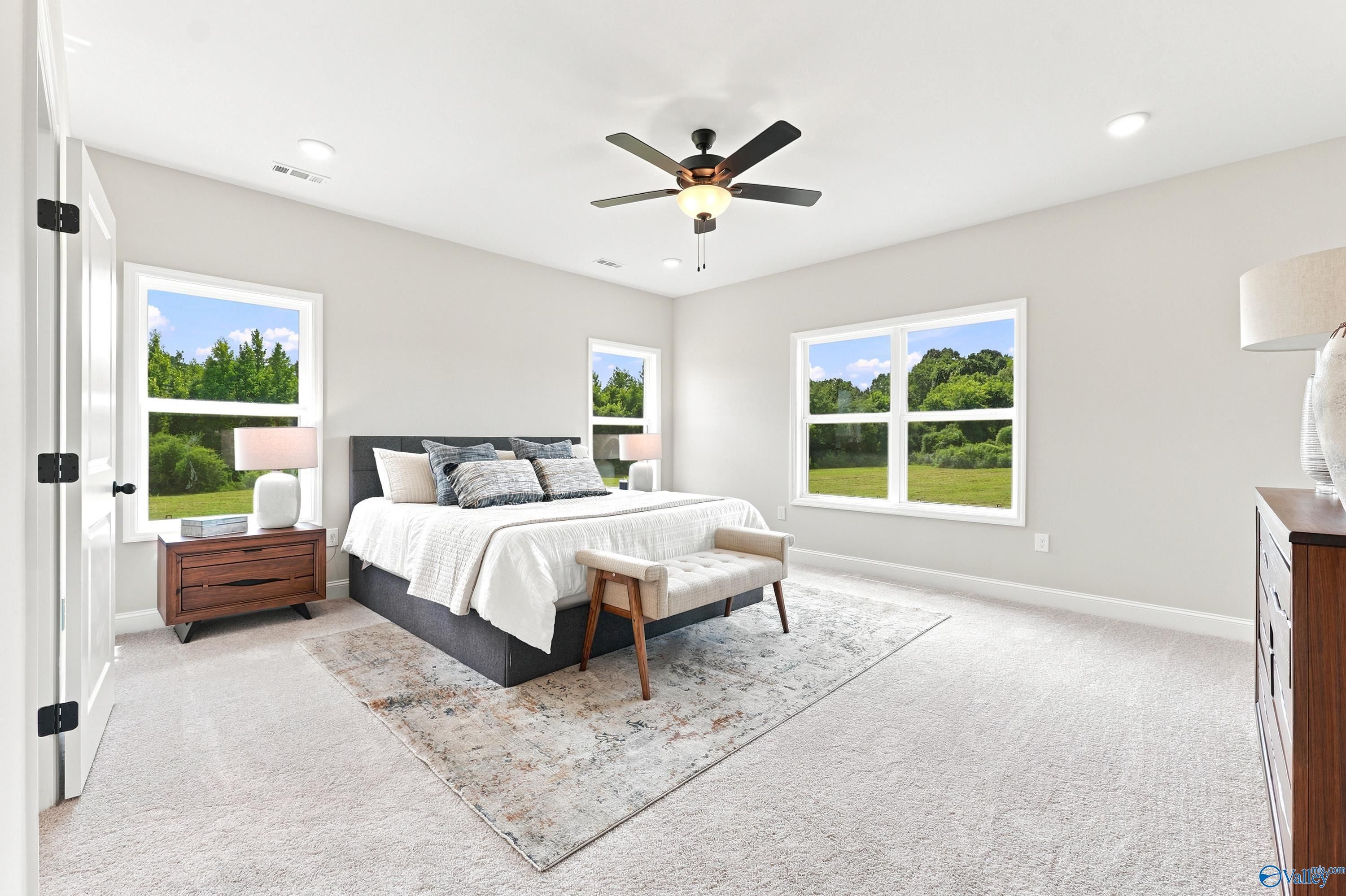 Spacious primary bedroom with large windows and neutral decor in The Finleigh floor plan at Riverton Preserve, Huntsville.