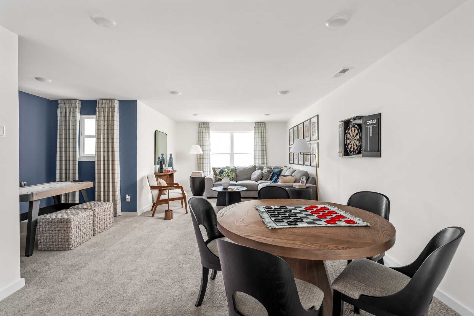 Spacious game room at Woods Crossing in Gallatin TN with pool table, checkers board, sofa, and dartboard accents