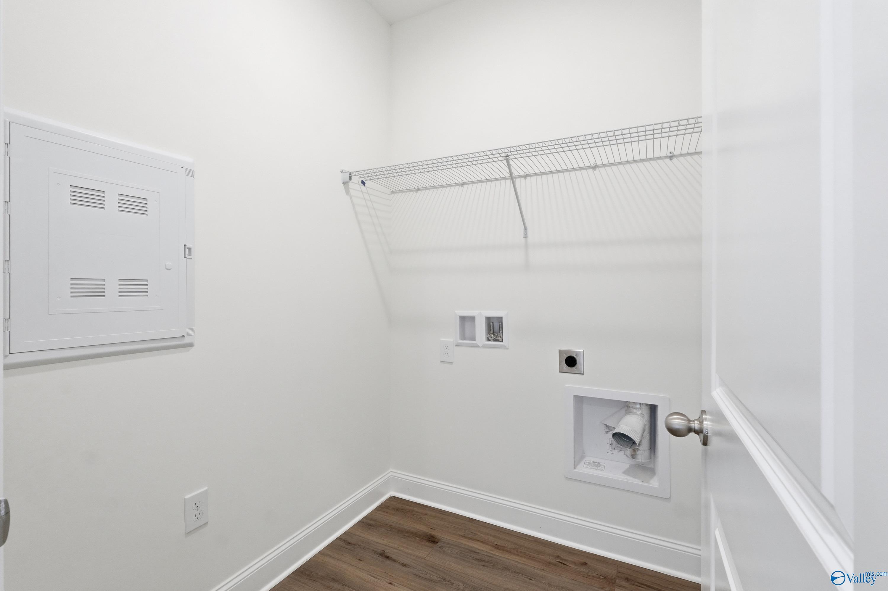 Laundry room with wire shelving and utility hookups in The Asheville floor plan at Jaguar Hills, Huntsville, Alabama.