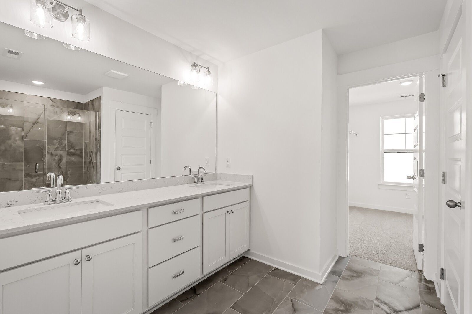Luxurious master bath double vanity with white quartz counters and large mirror in Davidson Homes The Willow D, Mt. Juliet, TN