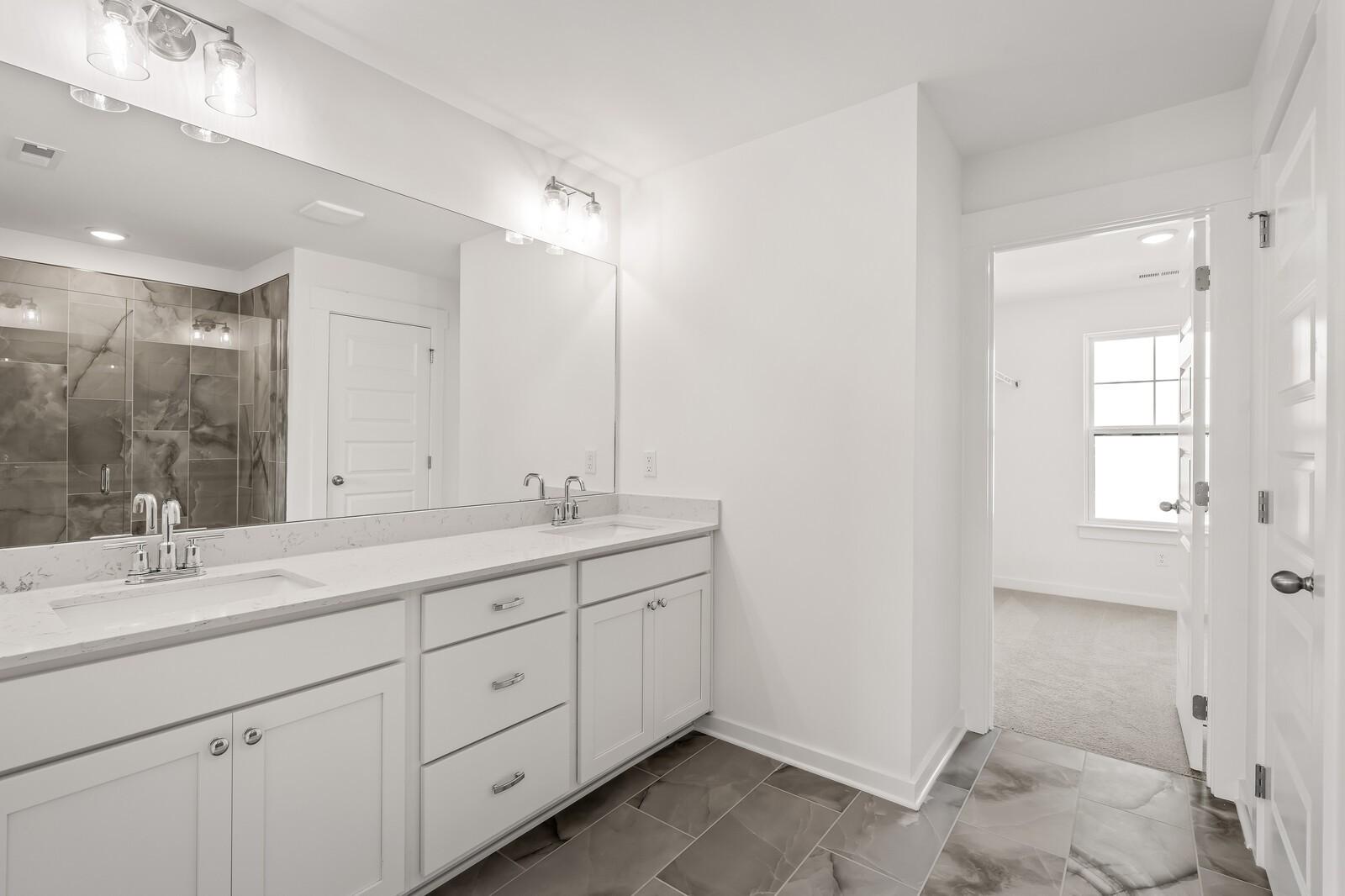 Luxurious master bath double vanity with white quartz counters and large mirror in Davidson Homes The Willow D, Mt. Juliet, TN