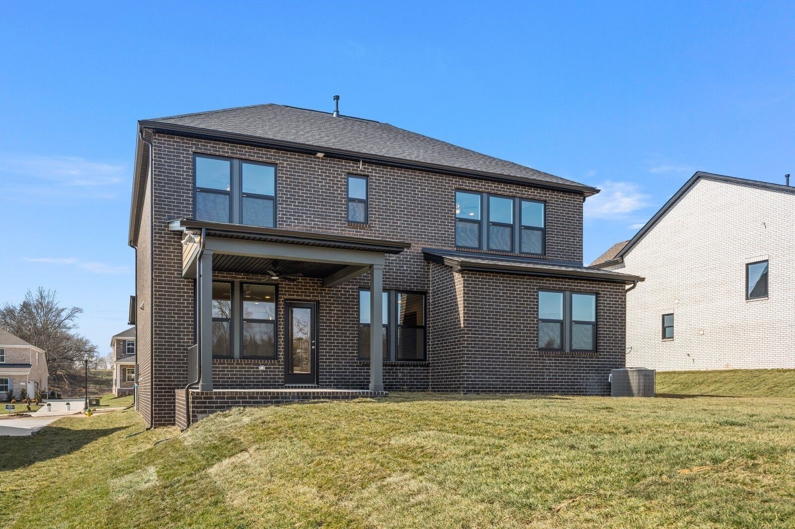Dark brick exterior of The Willow D floor plan by Davidson Homes with covered patio in Benders Cove, Mt. Juliet, Tennessee.