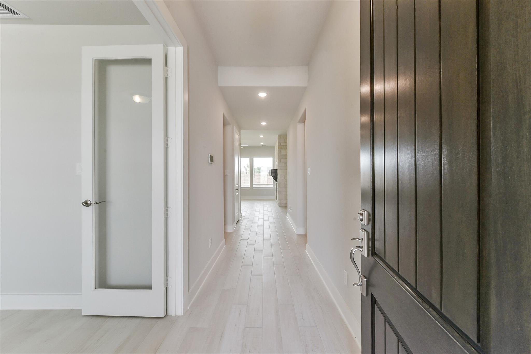 Bright entryway with wood-look tile flooring leading into The Edward C floor plan at Lago Mar in Texas City, Texas.