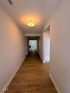 Bright hallway with wood-style flooring leading to open living area in The Daphne D plan, Woodland Crossing, Zebulon, NC.