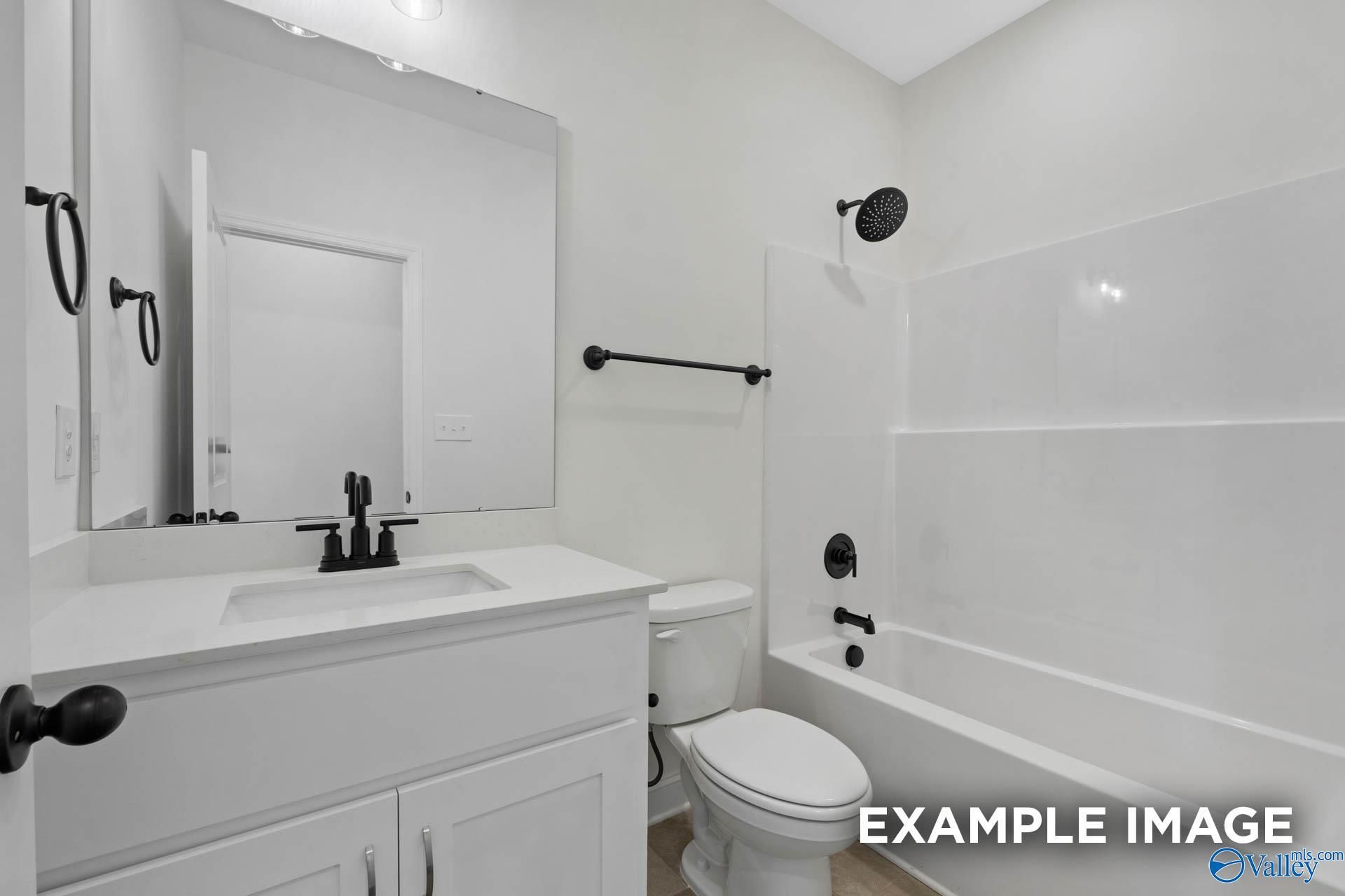 Modern bathroom with white vanity, matte black fixtures, and shower-tub combo in The Rockford B home, Briercreek, Alabama.