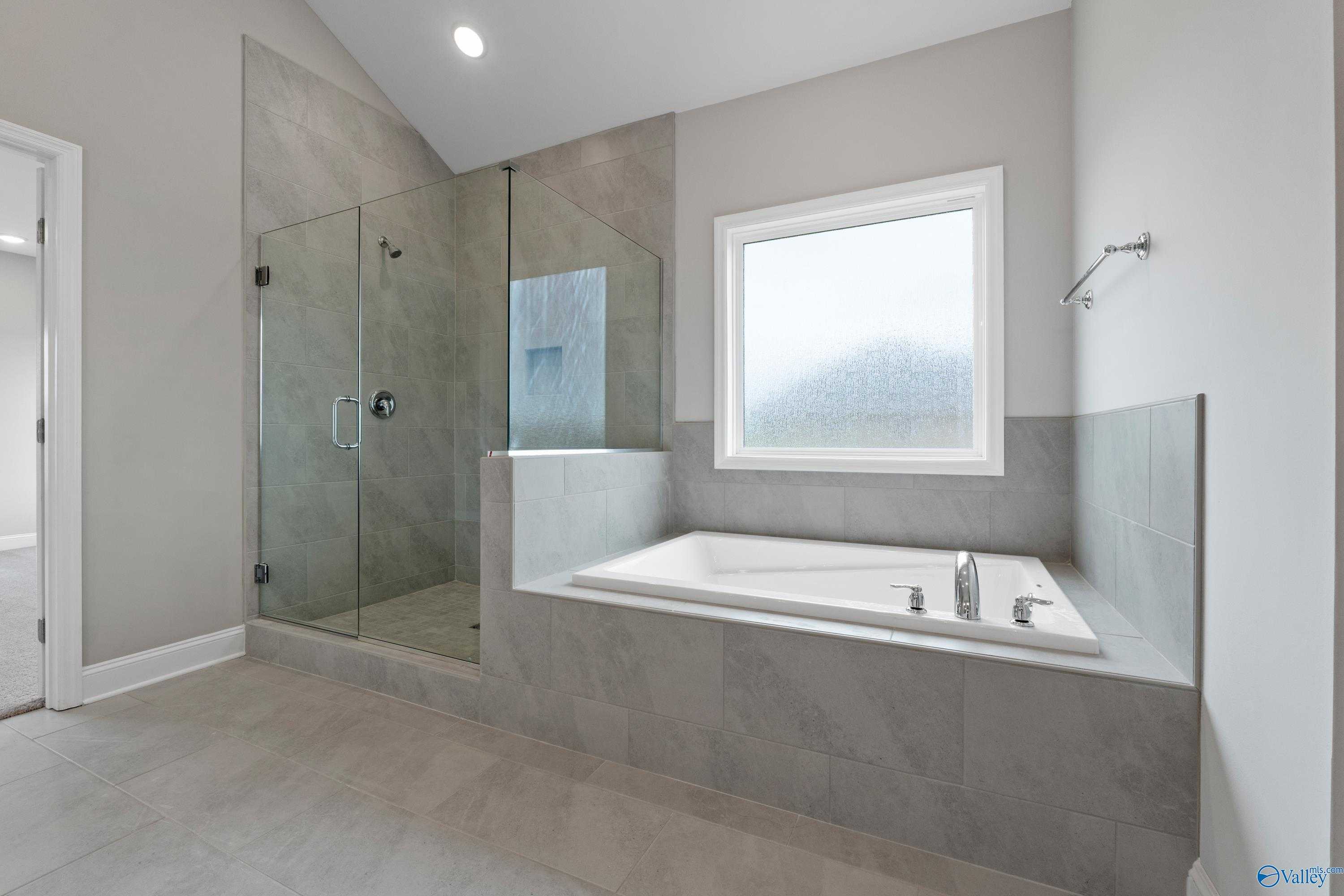 Luxurious master bathroom featuring frameless glass shower and freestanding tub in Davidson Homes The Finleigh, Meridianville, Alabama