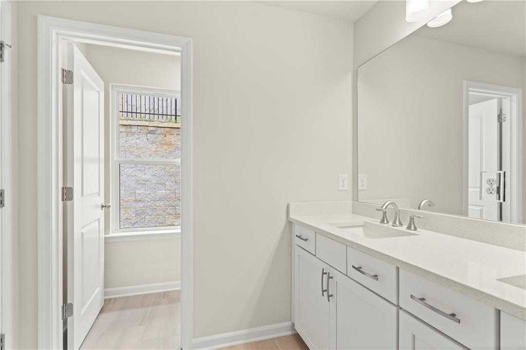 Modern double vanity bathroom with white quartz countertop and large mirror in Davidson Homes The Cary A, Kennesaw, Georgia
