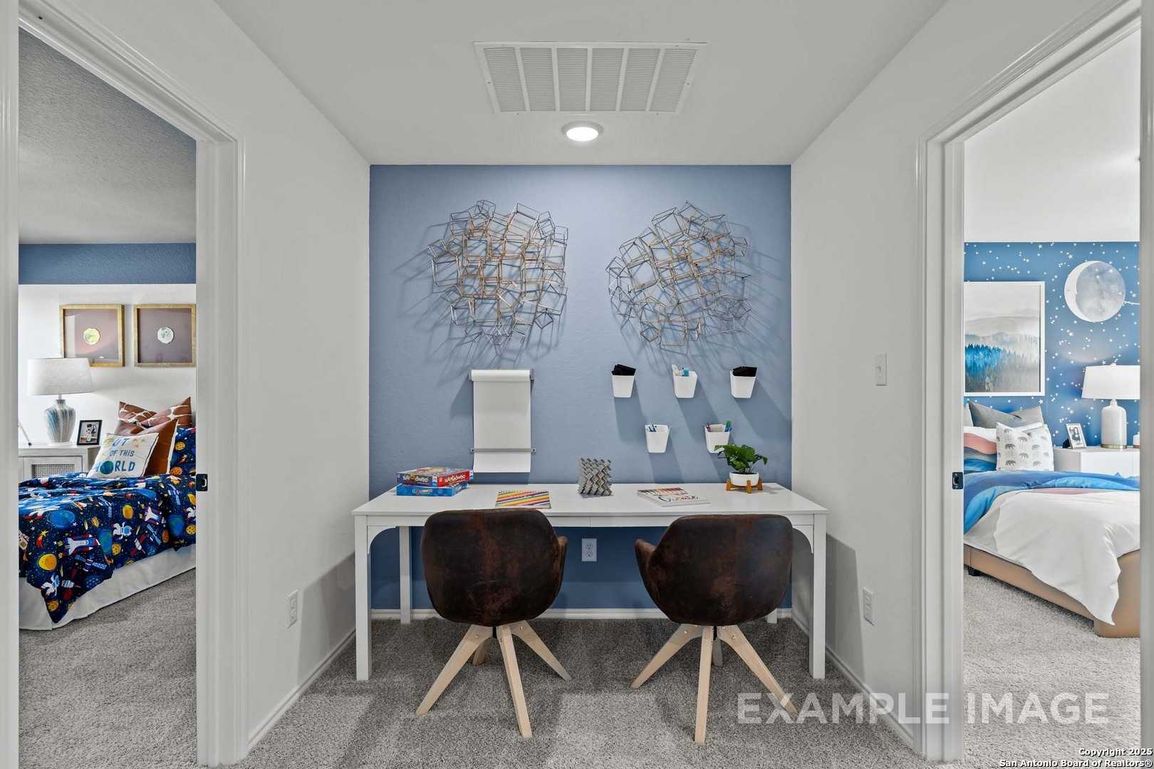 Upstairs study nook with white desk between space-themed kids' bedrooms, blue accent wall in Davidson Homes The Douglas C, Seguin, Texas