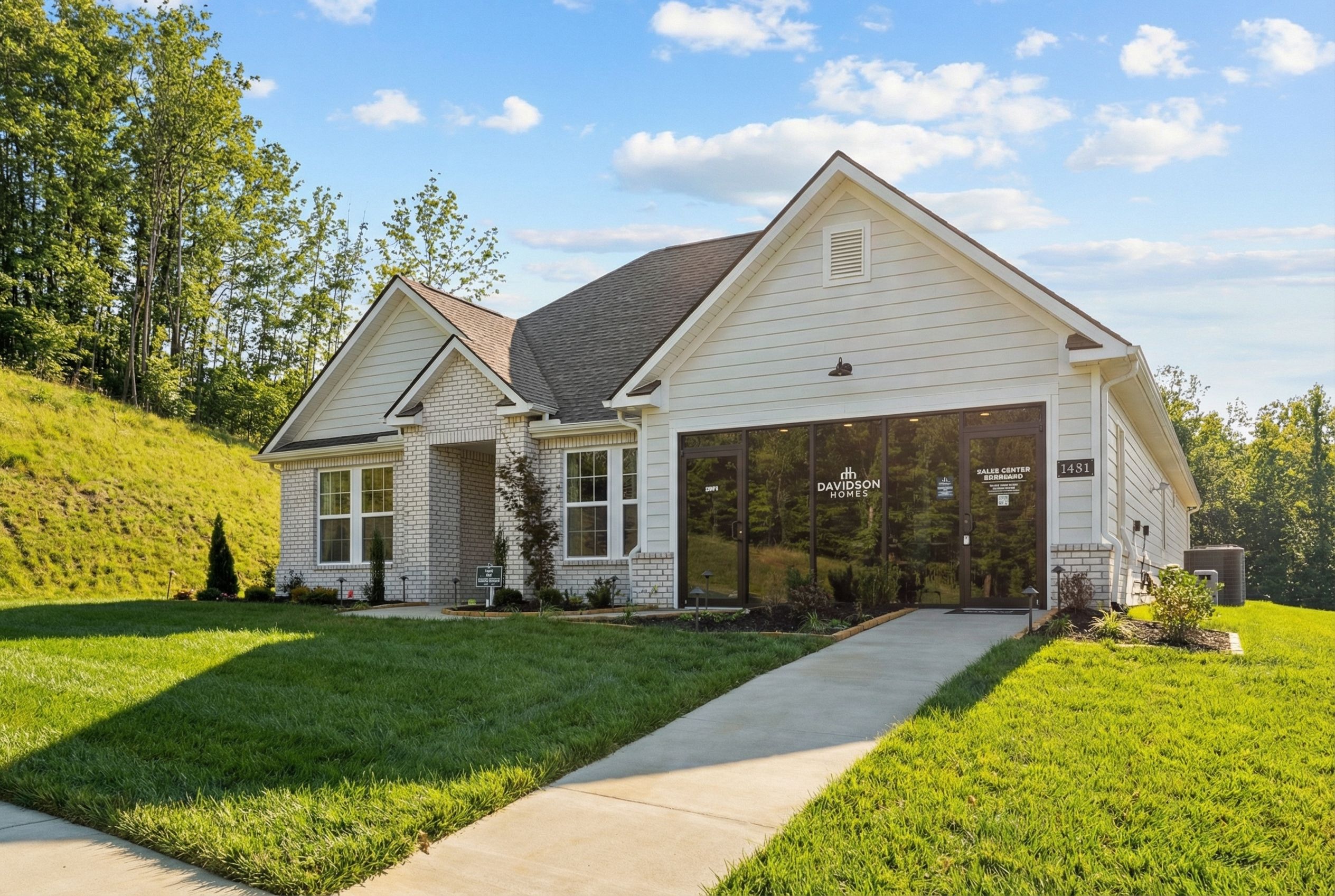 Craftsman model home exterior at Noble Ridge in Cullman Alabama by Davidson Homes with shake siding, covered porch and green lawn