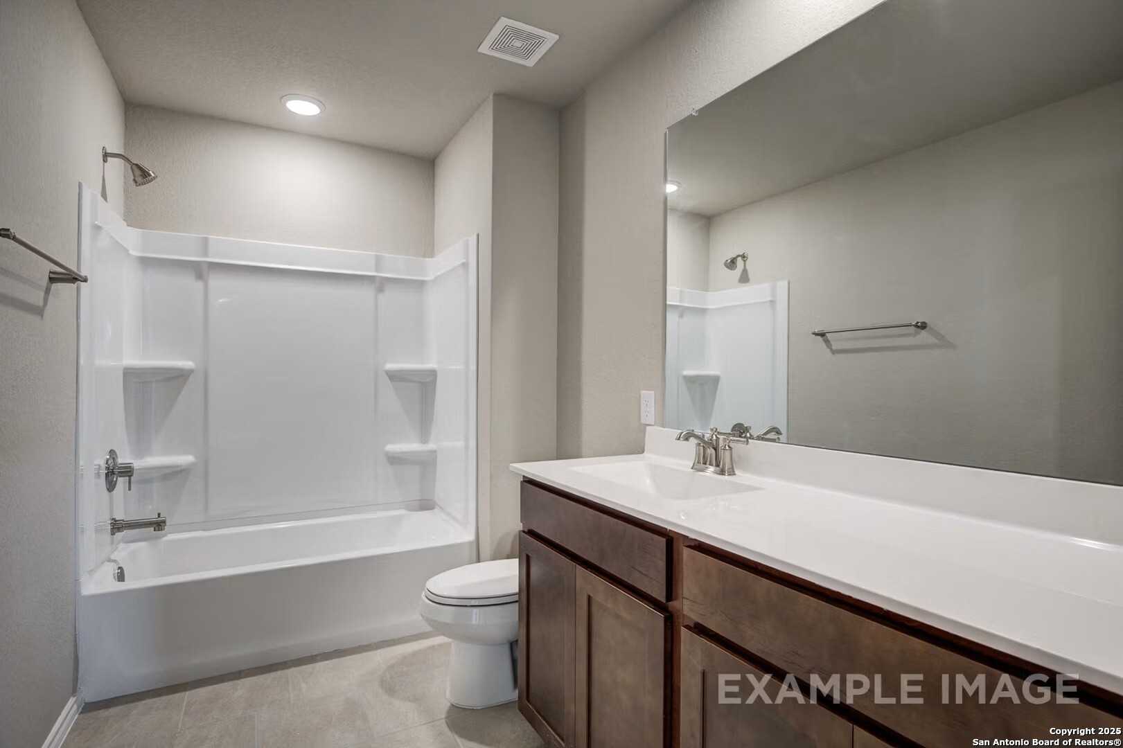 Modern master bathroom with white tub-shower combo, double vanity, large mirror in Davidson Homes The Murray K, San Antonio, Texas