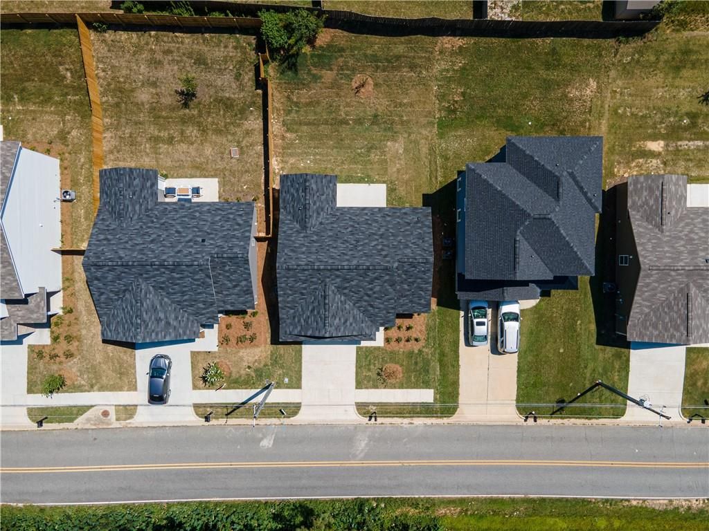 Aerial view of modern 1-story homes with dark shingle roofs, garages, and landscaped yards in Summer Vineyard, Phenix City, Alabama