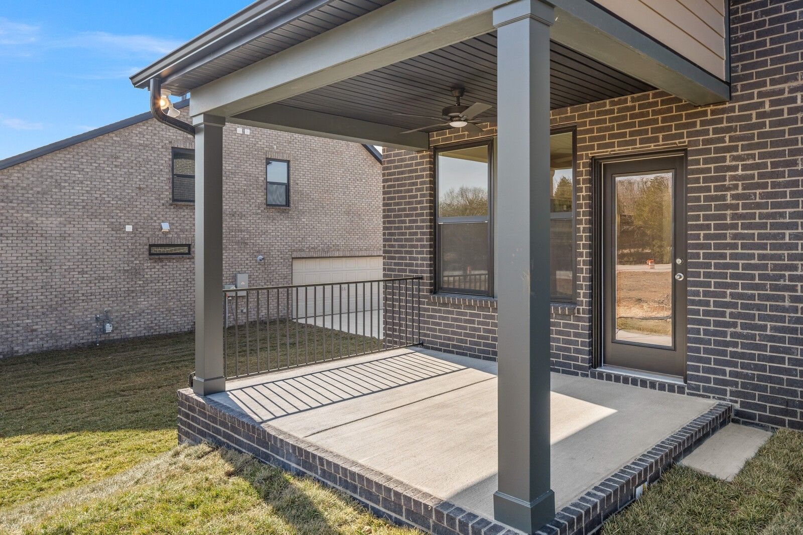 Covered back porch with ceiling fan, brick exterior, and glass door in 4-bedroom Davidson Homes The Willow D, Benders Cove, Mt. Juliet, TN