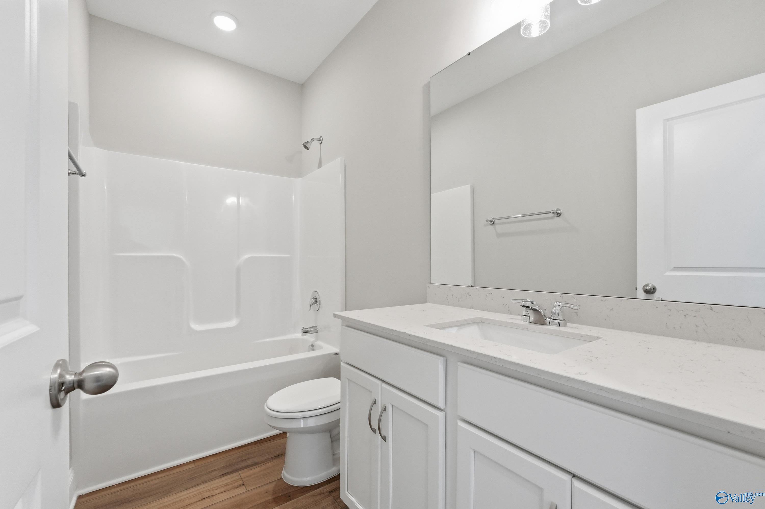 Modern guest bathroom featuring tub-shower combo, quartz vanity, white cabinets in Davidson Homes The Asheville, Huntsville, AL