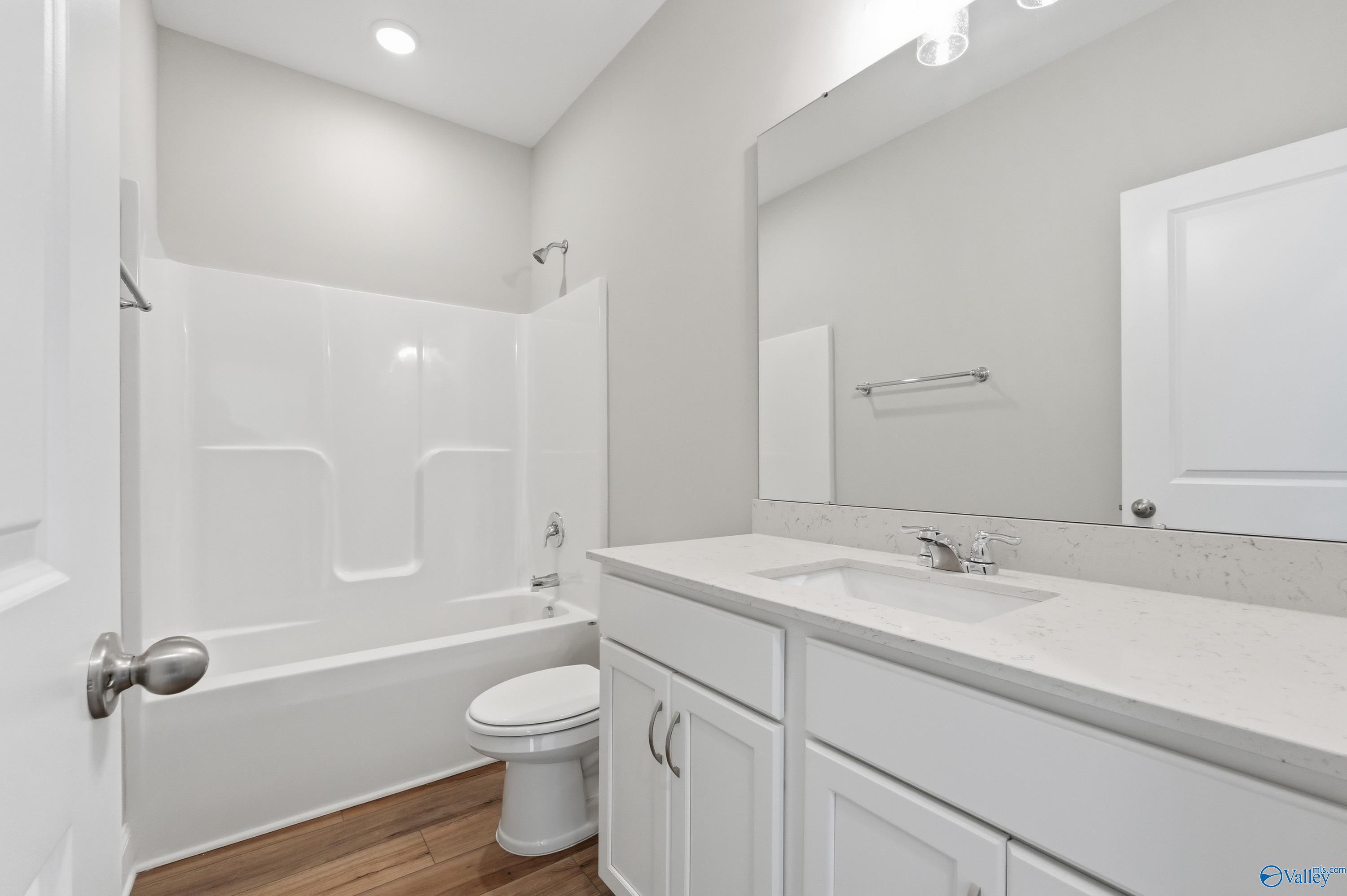 Modern guest bathroom featuring tub-shower combo, quartz vanity, white cabinets in Davidson Homes The Asheville, Huntsville, AL